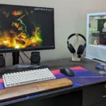 Cận cảnh bộ máy tính chơi game với màn hình IPS, bàn phím cơ, chuột và tai nghe trên bàn rộng