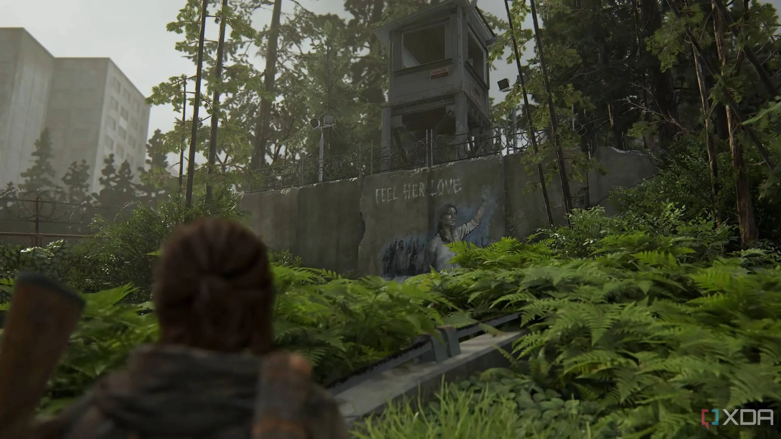 Ellie quan sát một bức tranh tường của Seraphites (Scars) trong game The Last of Us Part II Remastered, phản ánh sự hiện diện của phe phái này trong thế giới game.