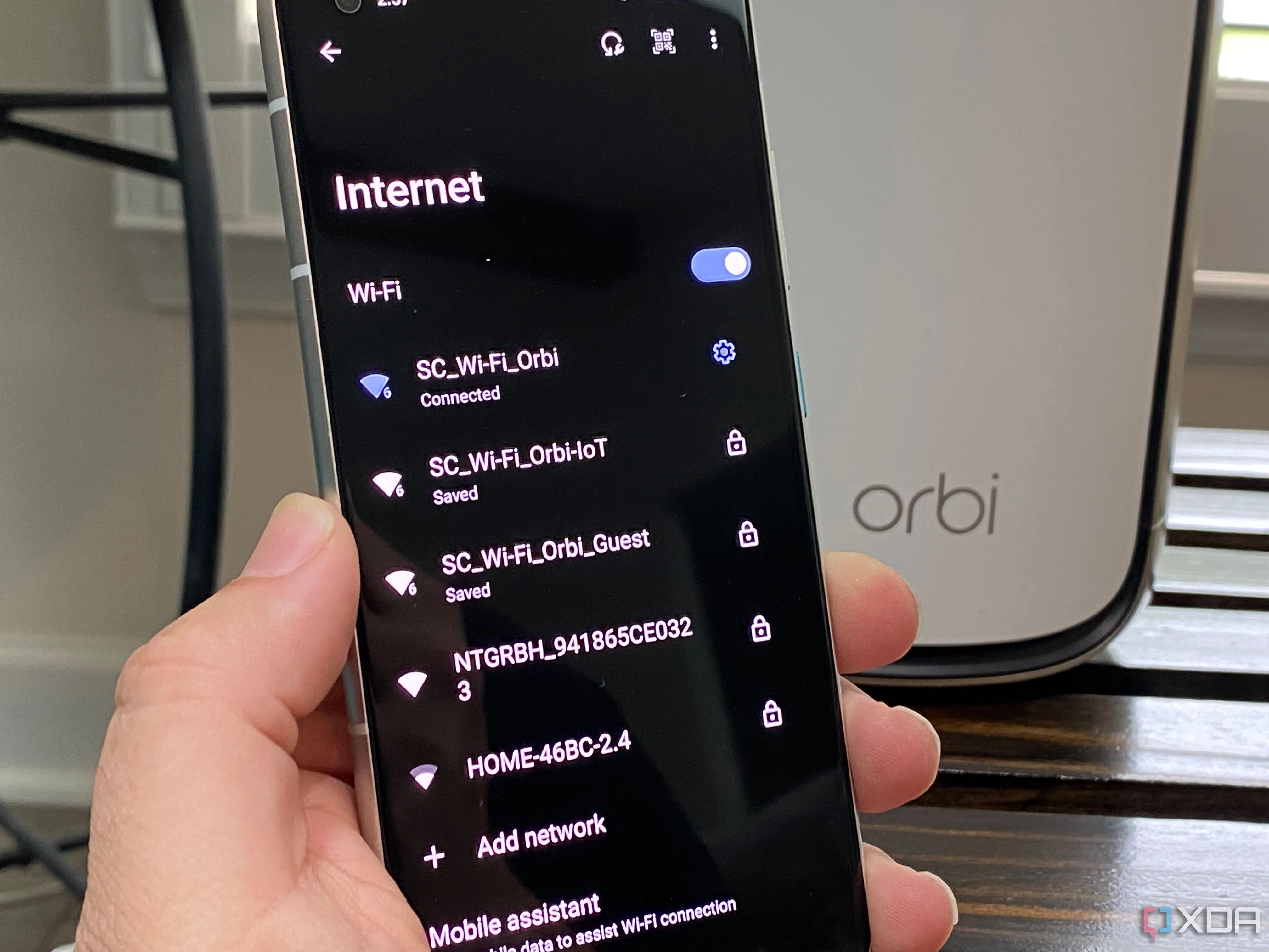 Màn hình điện thoại Android hiển thị các tùy chọn mạng Wi-Fi từ router Netgear, bao gồm mạng chính, mạng khách (Guest) và mạng dành cho thiết bị IoT, minh họa việc quản lý phân chia mạng hiệu quả.