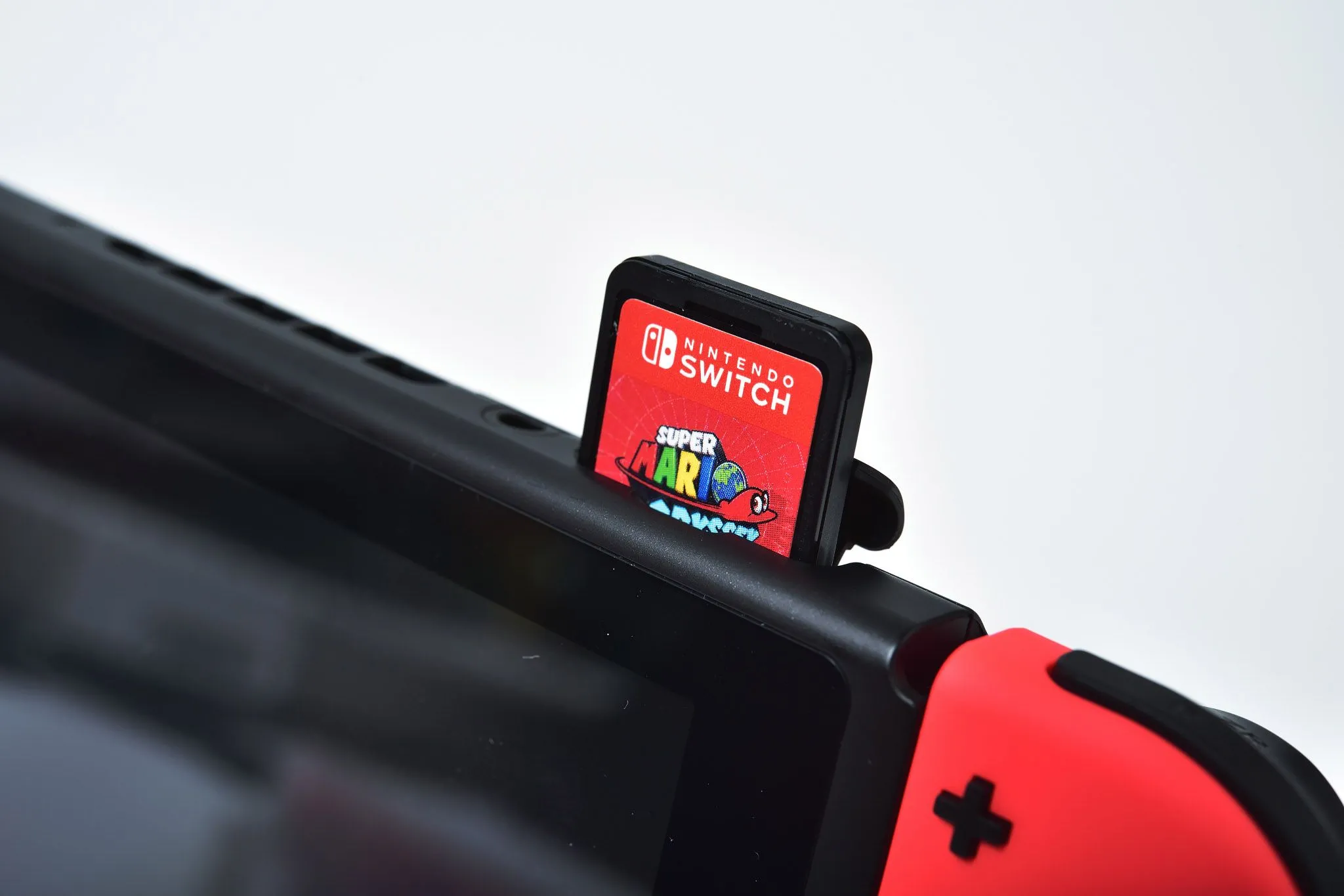Máy chơi game Nintendo Switch với thẻ game, biểu tượng cho những chính sách và quyết định của Nintendo