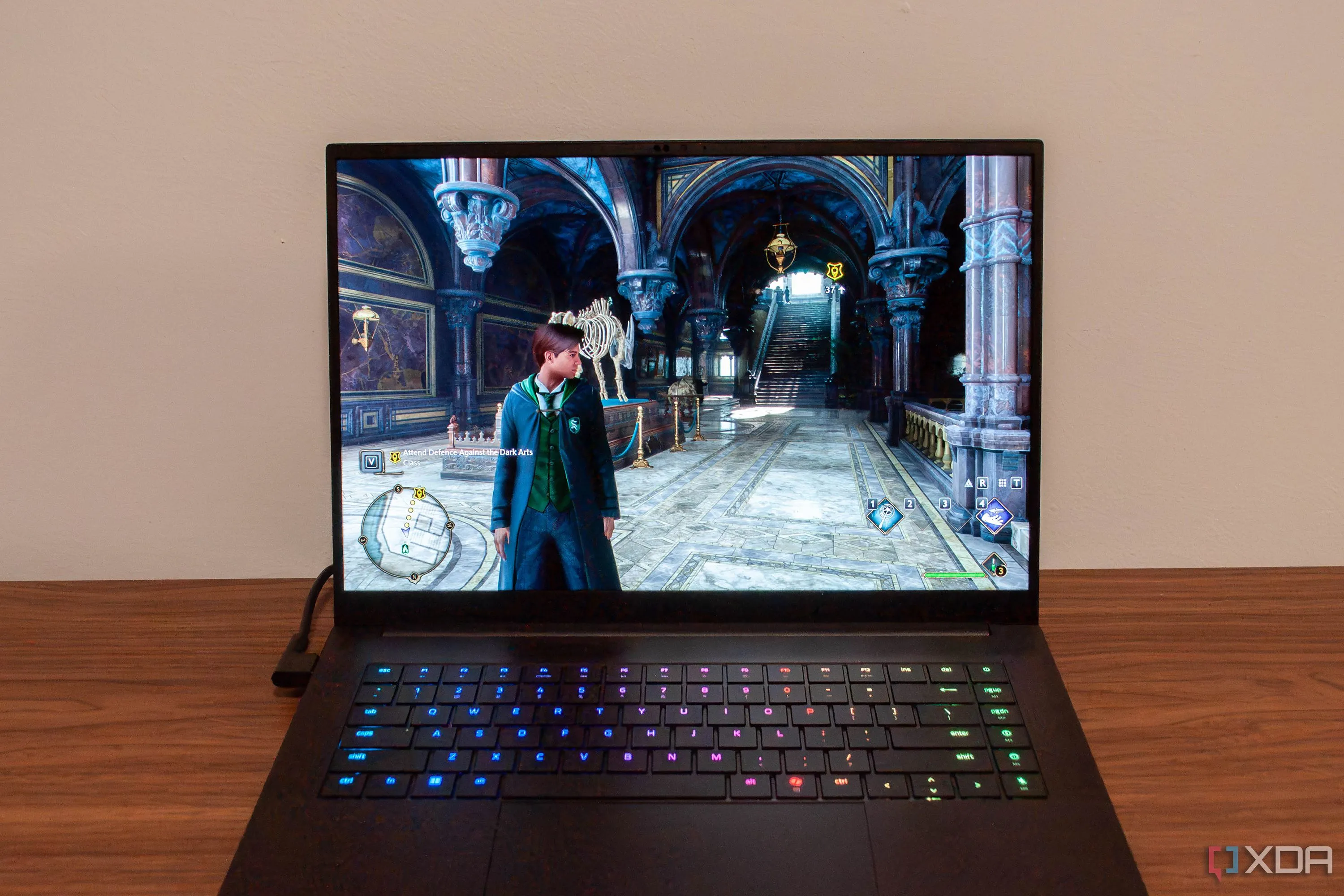Máy tính xách tay Razer Blade đang chạy trò chơi Hogwarts Legacy, thể hiện trải nghiệm haptic feedback tích hợp.