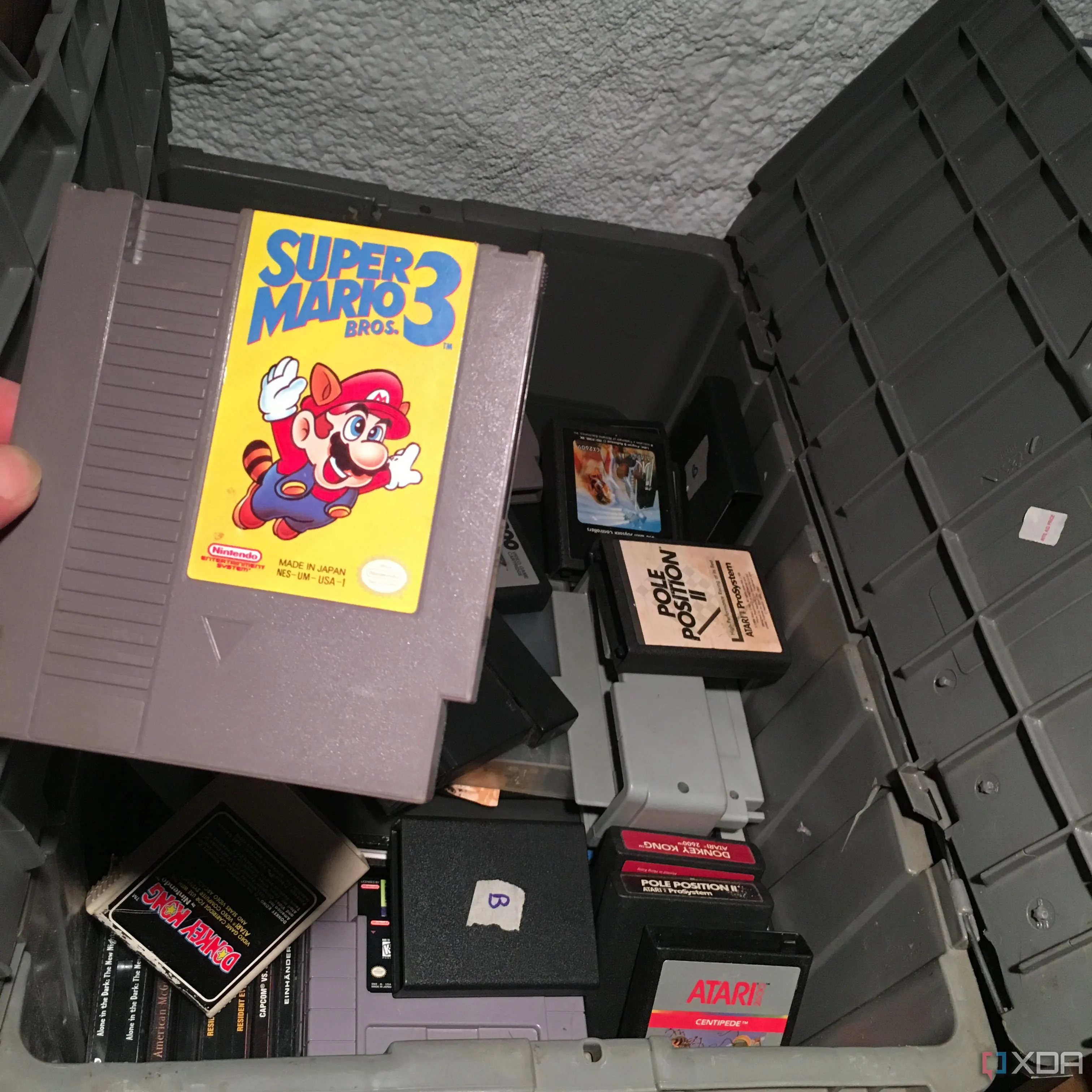 Người chơi kéo băng game Super Mario Bros 3 từ hộp trò chơi retro cũ, gợi nhớ kỷ niệm về các tạp chí game xưa