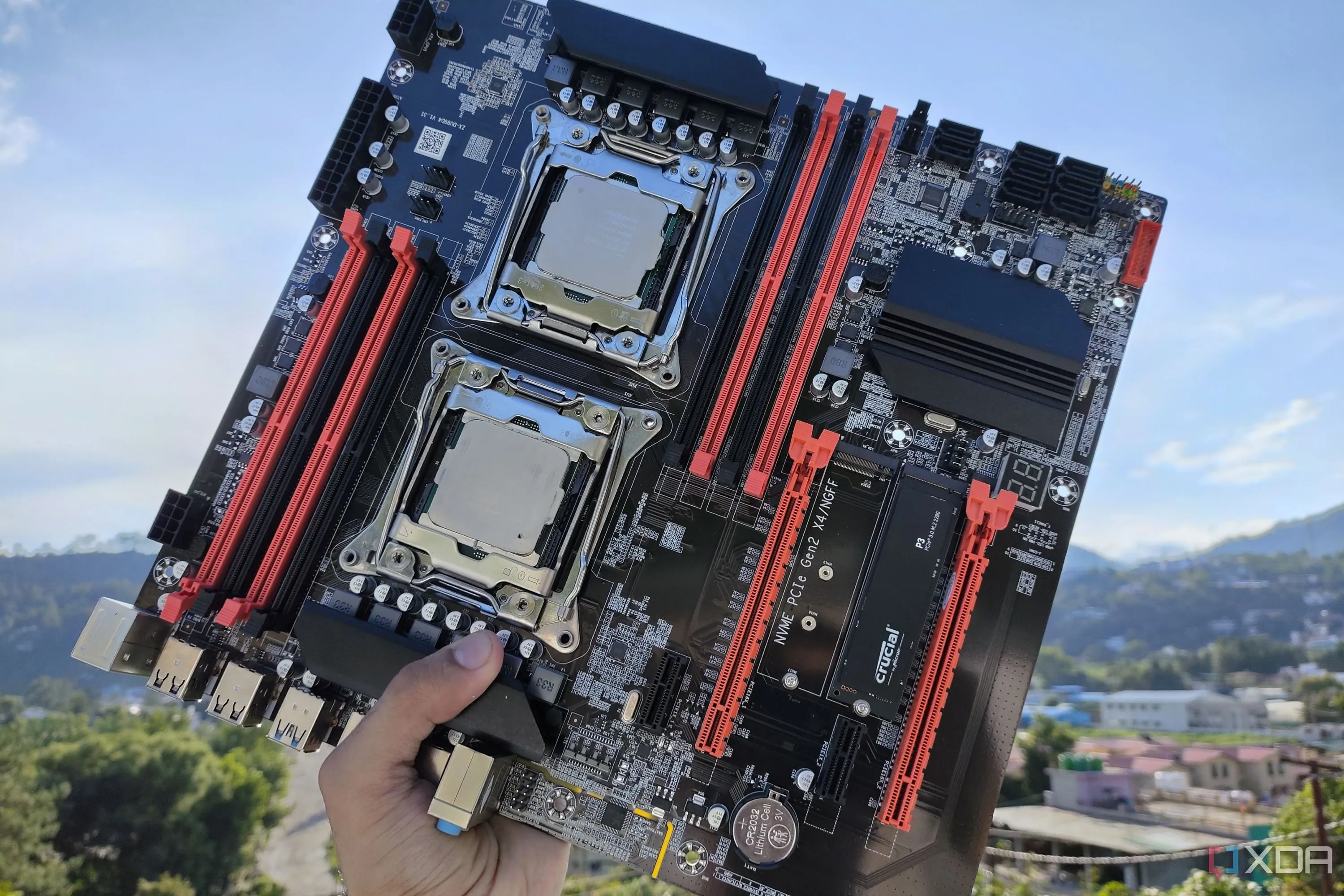 Người đang cầm bo mạch chủ máy chủ X99 với hai CPU Intel Xeon đã được lắp