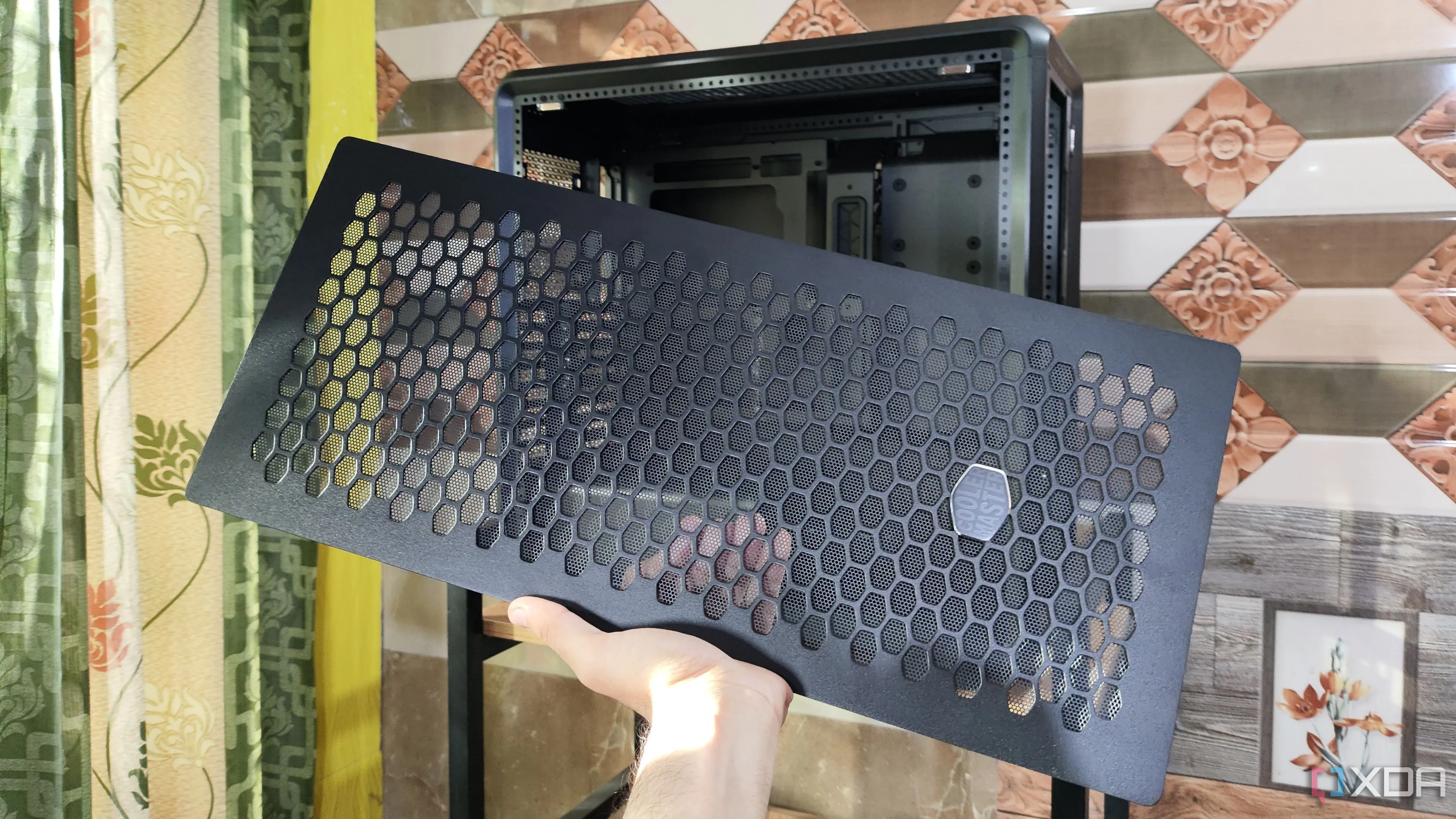 Người dùng cầm tấm mặt trước của vỏ case Cooler Master MasterFrame 600