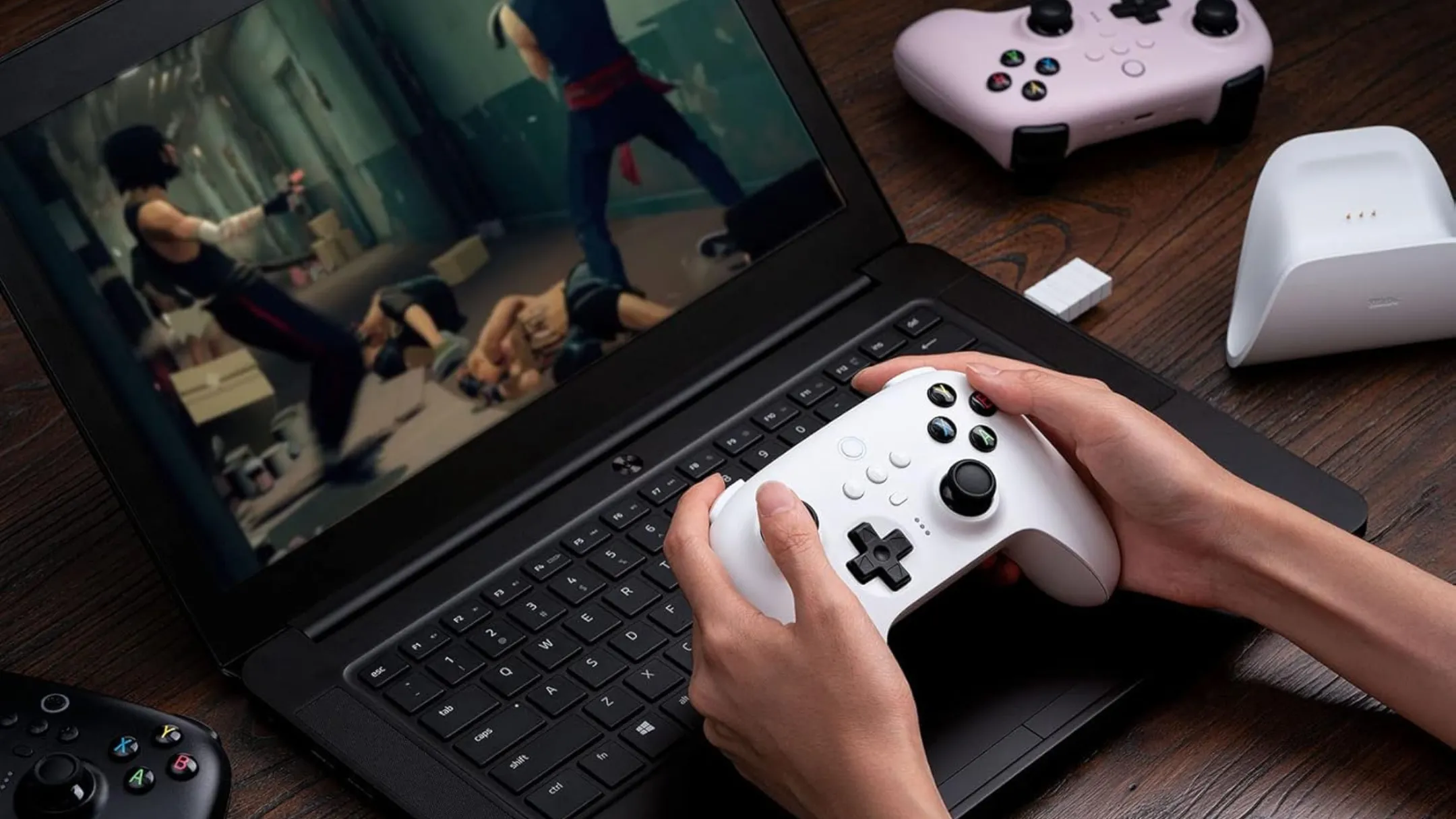 Người dùng trải nghiệm chơi game trên laptop với tay cầm 8BitDo Ultimate Wireless 2.4G