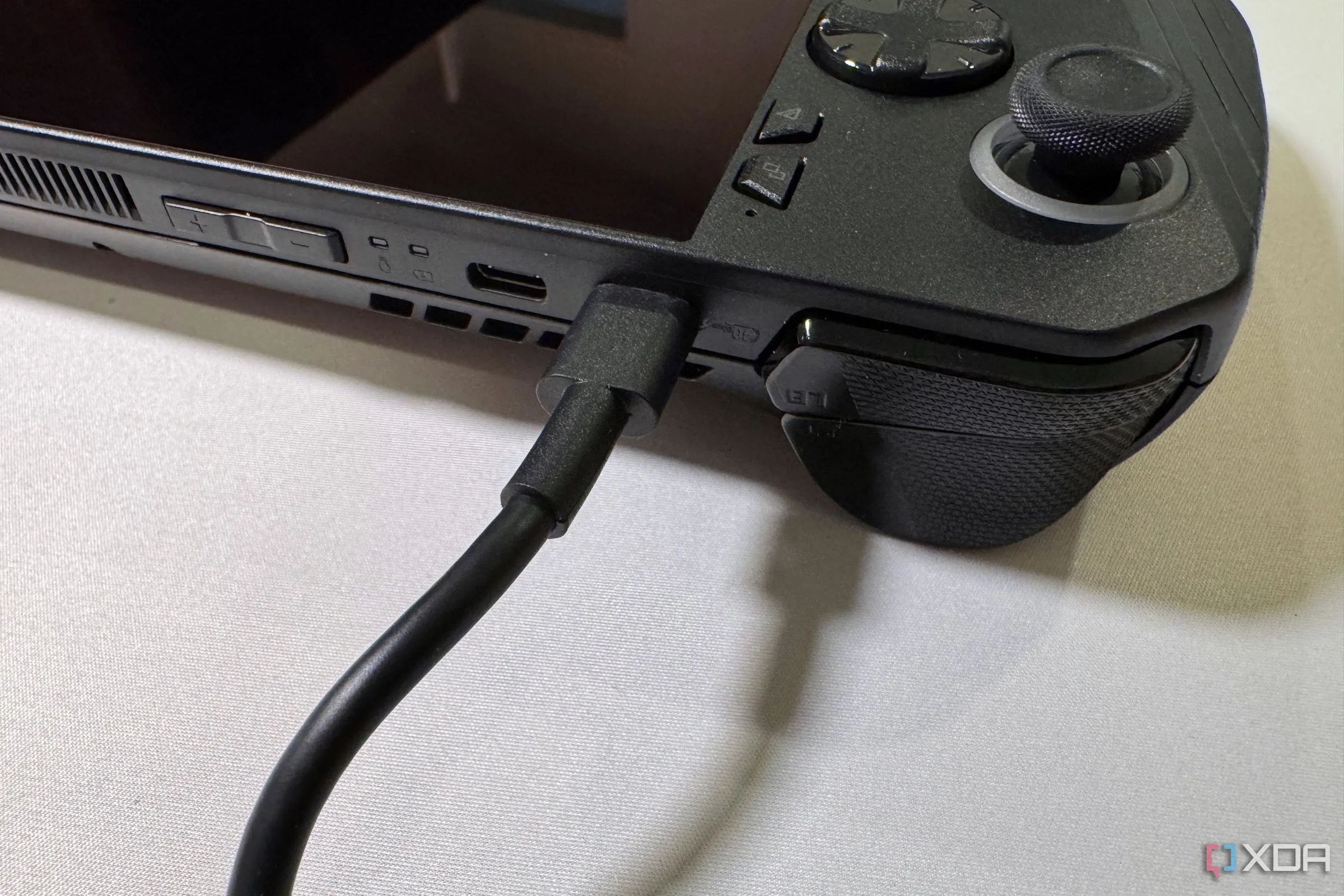 ROG Ally X đang kết nối cáp nguồn, minh họa cho việc sử dụng thiết bị chơi game cầm tay PC với eGPU