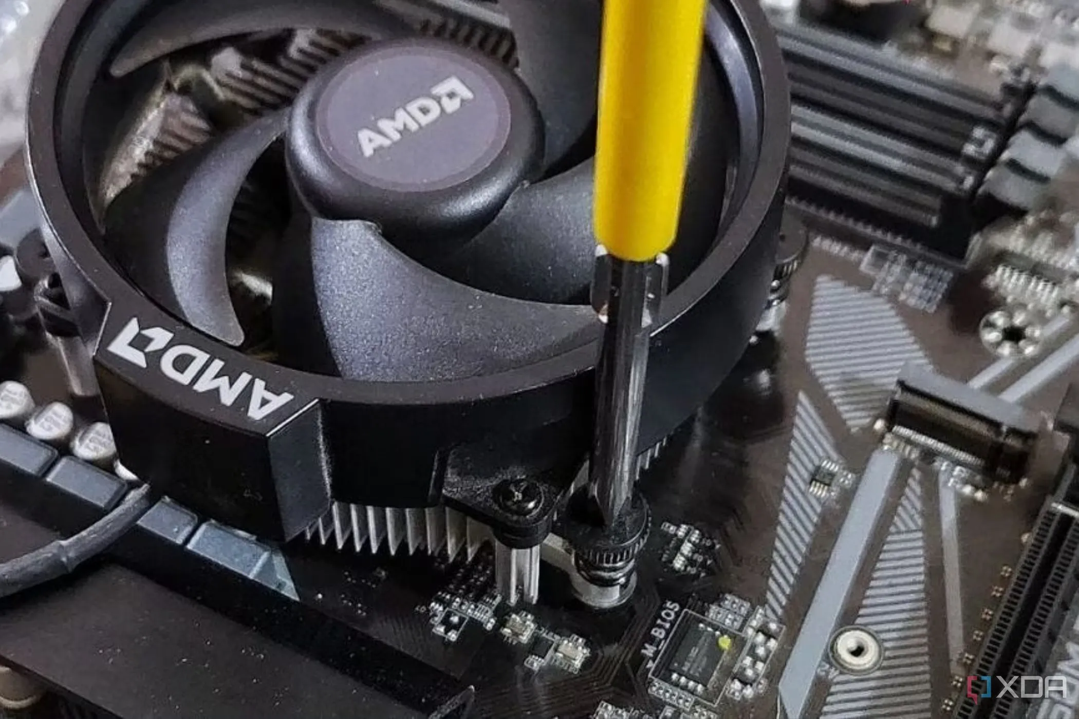 Tuốc nơ vít Philips siết chặt bộ tản nhiệt AMD lên bo mạch chủ